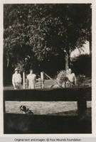 Men and a woman by fence