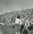 Cheerleader leading fans in a cheer during Homecoming Football Game, 1949