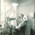 Dentist examining patient with nurse looking on, The University of Iowa, 1940s
