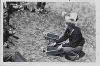 Kneeling Instructor showing box to group
