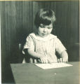 Girl points at a picture on a paper, The University of Iowa, ca. 1920
