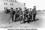 Cadets standing at ease with rifles next to Armory, The University of Iowa, 1922
