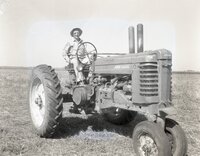 Farmer sits on tractor in field