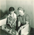 Girl and researcher playing with dollhouse, The University of Iowa, November 11, 1940