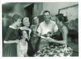Teacher and students looking at book, The University of Iowa, July 1957