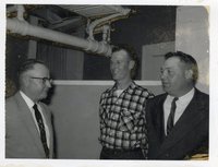 Three Unidentified Men Stand Facing Each Other with Pipes Overhead