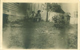 Man and woman posing with clotheslines in background, Calmar, Iowa, July 24, 1909