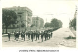 Marching band leading commencement procession west down Washington St. with McLean Hall, left, and Schaeffer Hall in background, The University of Iowa, June 1916