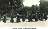 Commencement procession walking south on Clinton Street by Unity Hall (right) and turning west towards Old Capitol, The University of Iowa, June 1920