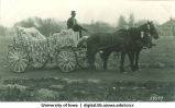Students seated in a decorated horse-drawn carriage, The University of Iowa, 1920