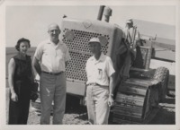 Harold Shold, Bill Beddow, and Lois Beddow pose in front of a tractor.