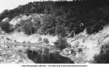 Coal Measure Shale (middle of picture) resting in eroded channel in St. Louis sandstone (seen in lower corners of picture) on Cedar Creek, Bellefontaine, Iowa, late 1890s or early 1900s.