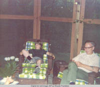 John, Jr. and unknown man sitting in screened in porch