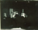 People observing a woman and girls working on crafts from an adjacent darkened room, The University of Iowa, October 28, 1938