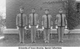 Officer and three non-commissioned officers standing next to Armory, The University of Iowa, 1913