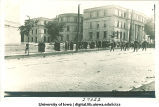 Commencement procession and marching band heading west on Washington St. with Schaeffer Hall in background, The University of Iowa, June, 1913