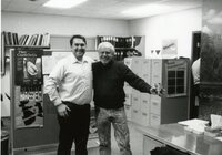 1992 - Two smiling men stand in office