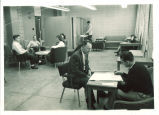 Professor Carroll Colemann with students in lounge of Communications Center, The University of Iowa, 1950s
