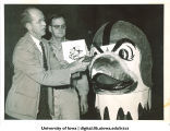 Arnold Gillette and Joy Anderson with new helmeted Herky head before it travels to the Rose Bowl, The University of Iowa, December 27, 1956