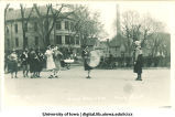 Marching band with men in women's attire, Mecca Day parade, The University of Iowa, 1921