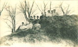 Women sitting on large haystack, Iowa, March 12, 1908