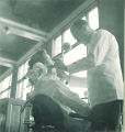 Dental student examining patient, The University of Iowa, 1940s