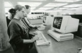 Two students using computer stations for research