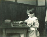 Girl playing with small shapes in frames, The University of Iowa, ca. 1920