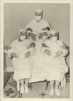 Nurses pose with newborns.