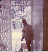 Ainsley Benard sweeping snow off the steps of White house with Victoria, the dog