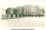 Cadet leading commencement procession west down Washington St. with Schaeffer Hall in background, The University of Iowa, June 1913
