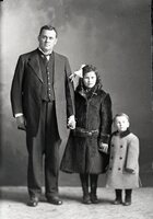 Man, girl and toddler in coats