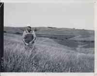 Property owner Lester Willams examines some native grass.