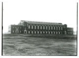 Two men working on the front (north) side first floor windows of State Gymnasium