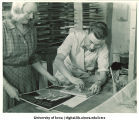 Carolyn Pickett and Ed Shaw working on war poster design in War Art Workshop, The University of Iowa, 1942-43
