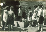 First graders watching a student feed a chicken, The University of Iowa elementary school, May 1932