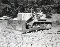 Man sits on bulldozer in field