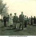 Officers walking behind the crowd on a field, The University of Iowa, 1950s