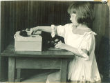 Girl playing at a table, The University of Iowa, ca. 1920