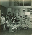 School children and their teacher with rug display, The University of Iowa, 1925