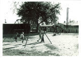 Children on swing-set outside a married housing unit, the University of Iowa, April 18, 1958
