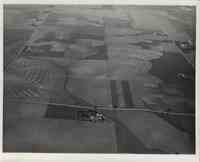 Squares of farmland with houses surrounded by roads