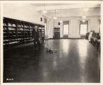 Mr. Roe waxing the floor in the Bookends Reading Room (Periodical Reading Room), 1927