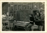 Aircraft parts are listed on the blackboard and displayed on a table, 1943