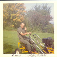 Leo Heitzman on lawn mower, smoking a pipe