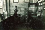 Man looking out window of pharmacy laboratory, The University of Iowa, 1930s