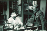 Dentist performing clinical work with colleague looking on, The University of Iowa, 1940s