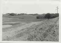 Farmland with watershed and trees in back