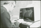 Professor enters data into early computer, 1973