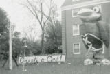 Alpha Gamma Delta Homecoming lawn display, ""Corset's a cinch,"" 1962